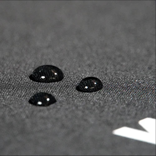 Close-up of black textured surface with water droplets highlighting rugged material for edgy streetwear mousepad.